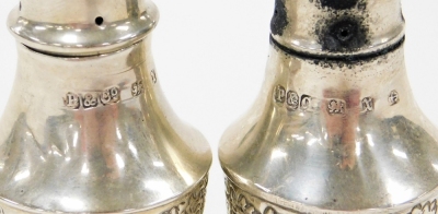 A pair of late Victorian small pepper pots, each with embossed C scroll decoration, Birmingham 1897, ¾oz, 7cm high. - 2