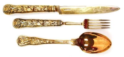 A George IV silver gilt three piece cutlery set, each heavily embossed with dogs, boars, hunting scenes, arrows and Medusa figures, each with varying hallmarks, the tablespoon possibly 1829, the knife London possibly 1827, and the fork with rubbed hallmar