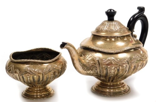 A late Victorian silver part tea set, comprising teapot and sugar bowl, with embossed scroll decoration and undulating gadrooned borders, two stepped circular bases, Birmingham 1900, 17oz all in.