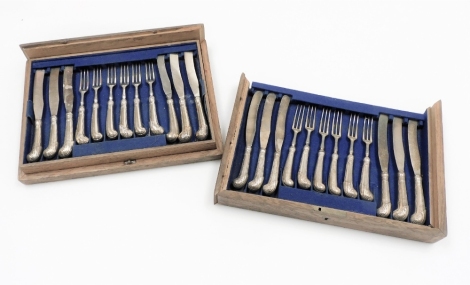 A cased set of twelve pairs of dessert knives and forks, each with crest of a deer and crown with shell capped pistol handles, silver plated, partially boxed.