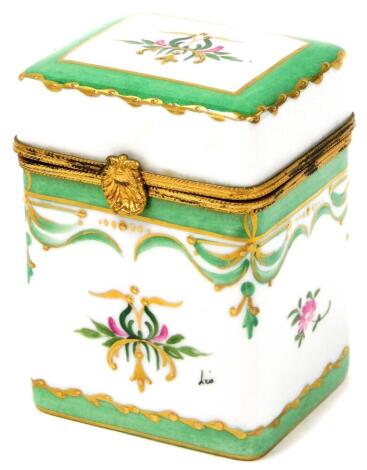 A Limoges porcelain trinket jar, with green enamelled decoration picked out in gilt with flowers, on a lift up acanthus shelf lid, with black stamped underside and green Limoges France, 10cm high, 7cm wide, 6cm deep.