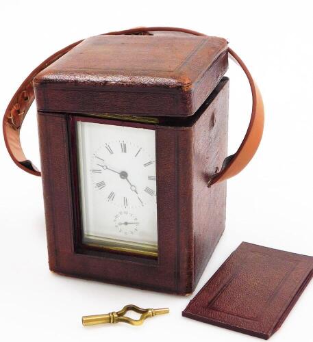 An early 19thC brass carriage timepiece, with white enamel dial with seconds dial in brass casing, the handle (AF) in a brown crush case, with key, 16cm high.