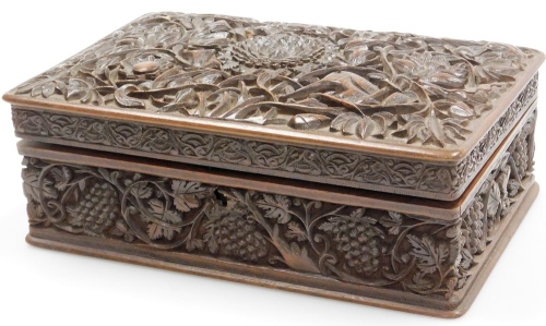 An Eastern carved hardwood rectangular box, the carving depicting birds with central flower, opening to reveal two layered sewing box section, with sewing accessories, 10cm high, 29cm wide, 19cm deep.