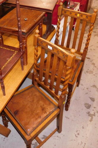 A set of four carved oak dining chairs, each with later inset leatherette and button seats, with front turned columns, 113cm high, 42cm wide.