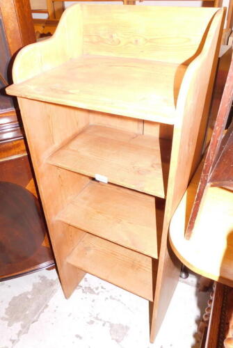 A pine bookcase, the shelf design top above three shelves, on an openwork base, 110cm high, 44cm wide, 33cm deep.