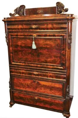 An early 19thC Biedermeier flame mahogany secrétaire à abattant, having a serpentine cushion drawer with oak lining to the surmount with scroll rococo supports, the cushion drawer over a fall flap revealing marquetry faced drawers with satin wood arabesqu