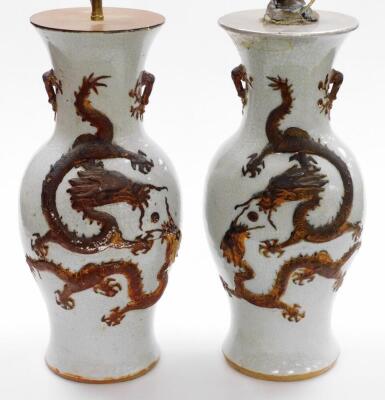 A pair of Chinese porcelain crackle glaze table lamps, each raised with a gilt dragon design, converted, with stamps to base, 46cm high.