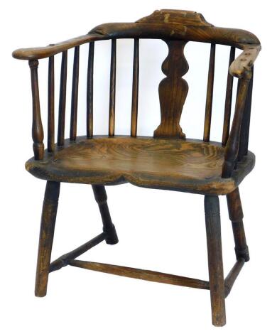 A late 18th/early 19thC rustic ash and elm Windsor type chair, with a shaped back, and a solid splat, and spindle turn supports, the dish seat stamped W.B. on ring turned legs, with H stretcher, 57cm wide.