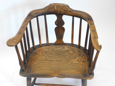 A late 18th/early 19thC rustic ash and elm Windsor type chair, with a shaped back, and a solid splat, and spindle turn supports, the dish seat stamped W.B. on ring turned legs, with H stretcher, 57cm wide. - 2