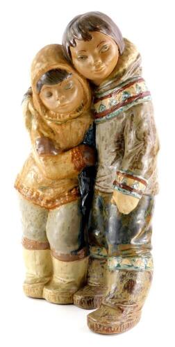 A Lladro brown ceramic figure group, modelled in the form of two embracing Eskimos, printed mark in blue to underside, 38cm high.