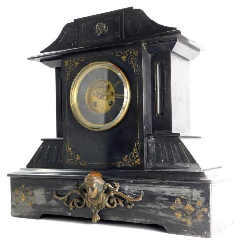 A late 19thC French black slate and bronzed metal mantel clock, decorated with Neoclassical masks, foliate scrolls, with a bevelled glass mounted to the brass bezel, the blackened chapter ring with gilt Roman numerals, 45cm high, 48 wide.