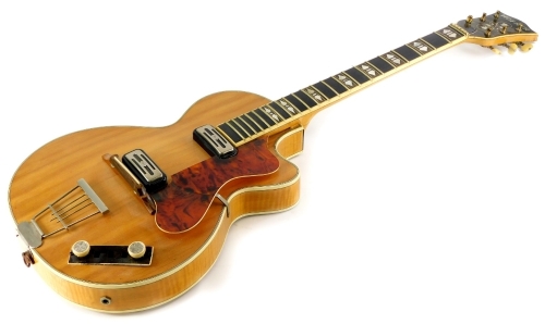 A Hofner electric guitar, with plated mounts, the ebonised finger board inlaid with mother of pearl two piece maple back, with simulated ivory borders, 97cm long.