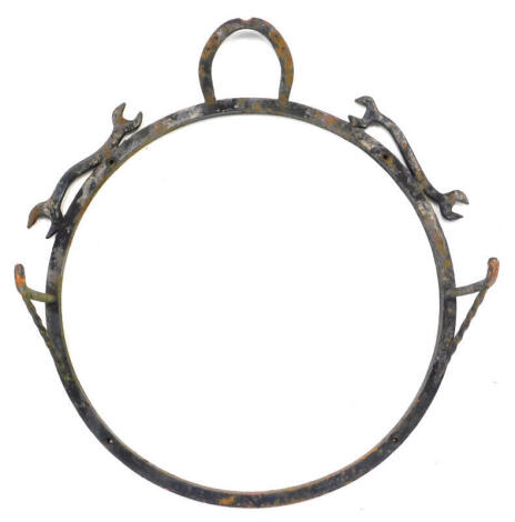 A blacksmith made wrought iron wall display bracket, decorated with horseshoes and spanners, with two arms, possibly for a sign or hanging baskets, etc., 84cm diameter.