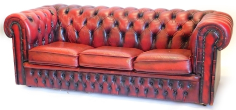 An oxblood red leather Chesterfield, with typical buttoned decoration and studded borders, 189cm wide. The upholstery in this lot does not comply with the 1988 (Fire & Fire Furnishing) Regulations, unless sold to a known exporter or upholsterer it will be