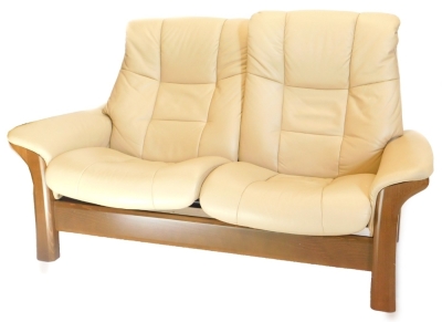 A Stressless Paloma beige leather two seat sofa, with 'walnut' coloured beech frame, 170cm wide.