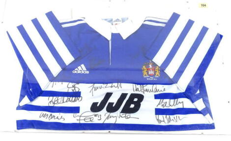 A Wigan Warriors Rugby League team signed shirt, probably for the season 1999-2000, bearing signatures of Brett Dallas, Paul Johnson, Terry Newton, Frank Endercott, etc., framed.