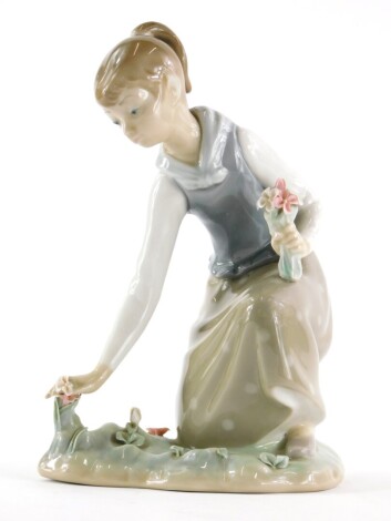 A Lladro figure, of a girl picking flowers on naturalistic base, number I-6A, printed and impressed marks beneath, 20cm H.