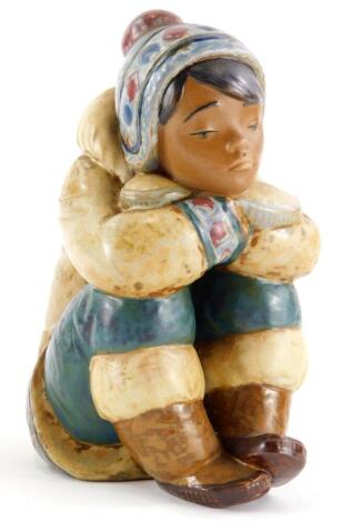 A Lladro porcelain figure of an Eskimo child, with head on hands, in seated position, printed mark in blue to underside, 17.5cm high.