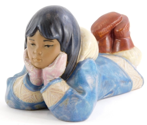 A Nao porcelain figure of an Eskimo child, lying on her front, 19cm long.