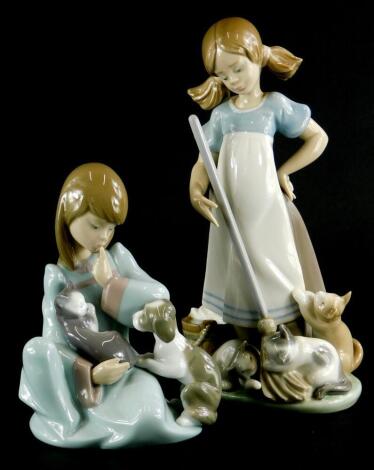 Two Lladro porcelain figure groups, one involving a lady with mop and kittens, and a young girl with puppy and kitten, the largest, 21cm high.