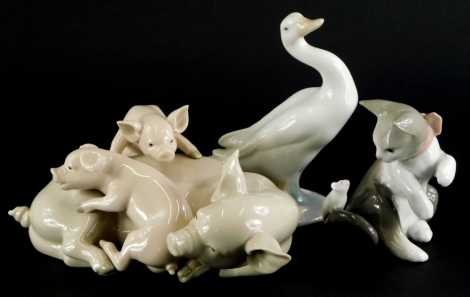 Three Lladro porcelain figures, to include a group of a pig with two piglets, a cat and mouse, and a goose.