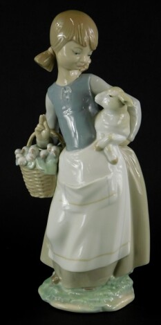 A Lladro porcelain figure group, of a young girl with basket and a lamb, printed marks in blue to underside, 25cm high.