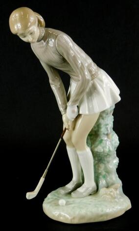 A Lladro porcelain figure of a female golfer, printed marks in blue to underside, 28cm high.