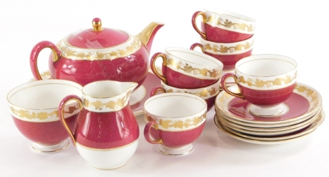 A Wedgwood Whitehall pattern part tea service, to include tea pot, milk jug, sugar bowl, cups and saucers, each with a mottled red band and a gilt band of grapes and vines, etc.