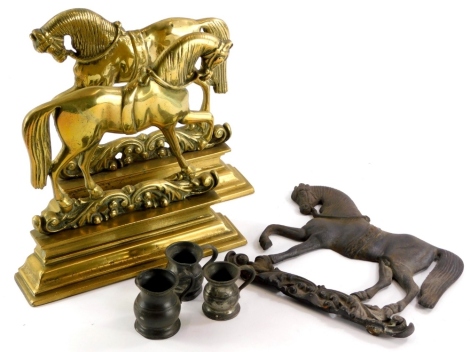 Miscellaneous metalware, to include a pair of brass door stops or fire place ornaments, each cast in the form of a horse on a rectangular base, 27cm long, a similar cast iron example stamped number 4, and three pewter measures.