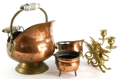 A collection of metal ware, to include a pair of brass griffin shaped candlesticks, copper coal scuttle, etc.