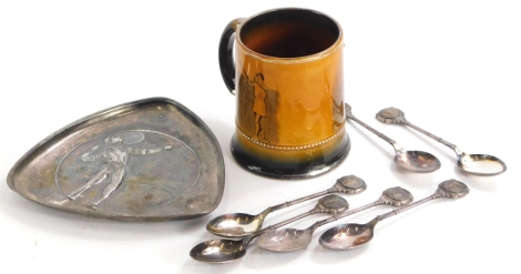 A continental pewter triangular dish, cast in the form of a tennis player with a net, in the manner of WMF, 15cm high, an Arthur Wood Sports series mug, printed with tennis players and a set of six silver plated spoons, each cast with a tennis player to t