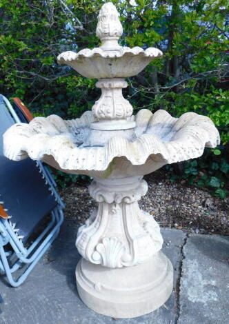 A composition two tier fountain, cast with shells, leaves, etc., on a tapering base, 133cm high, 90cm wide.