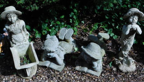 A pair of composition garden ornaments, modelled in the form of a recumbent child reading a book, and two other garden ornaments. (4)