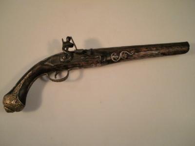 An old replica continental flintlock pistol with inlaid decorations and