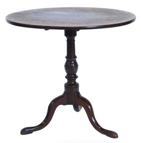 An early 19thC mahogany occasional table, with a circular top on a turned column and tripod base with pad feet, 77cm diameter.