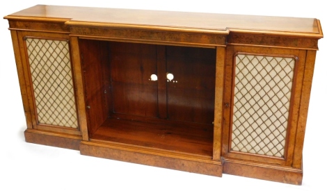 A Victorian walnut and burr walnut breakfront bookcase, the top with a moulded edge, above a central section with adjustable shelves, flanked by two doors, each with fabric backed brass grills, on a plinth base, 106cm high, 220cm wide, 46cm deep.