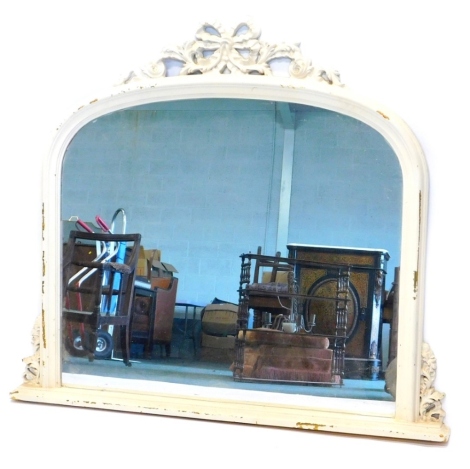 A cream painted oak overmantel mirror, with a carved ribbon and scroll decorated crest, and a moulded frame, signs of previous gilding, 106cm high, 110cm wide.