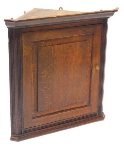 A 19thC oak corner cabinet, with a moulded cornice, with a single panelled door, 74cm high, 74 wide.