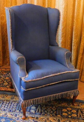 A wingback armchair, with cabriole legs and blue upholstery.