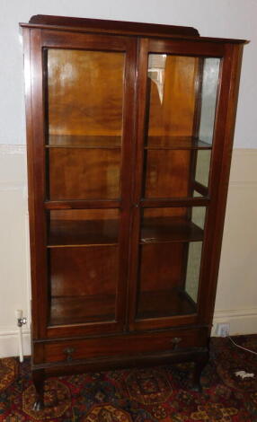 An early 20thC mahogany display cabinet, with two glazed doors, over single drawer and cabriole legs, 154cm high, 80cm wide.