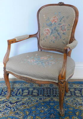 A 19thC French open armchair, with later floral upholstery.