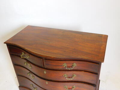 A George III mahogany serpentine chest, of two short and three long graduated drawers, oak lined and cock beaded with brass cast loop handles and bracket feet, 85cm high, 105cm wide, 60cm deep. - 2