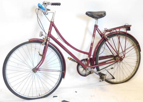 A vintage Raleigh ladies bicycle in purple, with chrome coloured handles and back shelf, 102cm high.