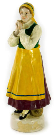 A German Schwarzburger werkstatten figure of a peasant lady, wearing a yellow pinafore and brown dress, impressed mark, the base inscribed S. Douglas, 19cm high.