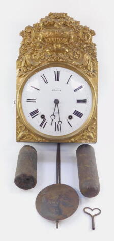 Jeannin A' Buxy. A 19thC gilt brass comtoise wall clock, with elaborate repousse decoration, with urns, scrolls and flower heads, raised above a curved 24cm diameter enamel Roman numeric dial, striking on the half hour, with two weights, pendulum and key,