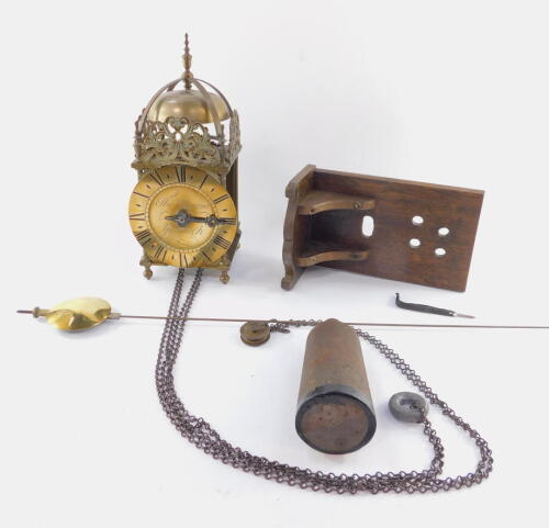 A 19thC brass hook & spike lantern clock, engraved for Thos Moore, Ipswich, surmounted by a strapped bell, with four urn finials between pierced scroll frets, over tapering columns, on ball feet, 17cm diameter Roman numeric dial signed Tho. Moore Ipswich,