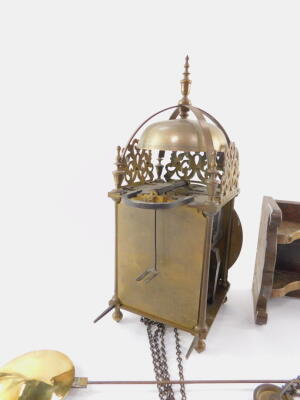 A 19thC brass hook & spike lantern clock, engraved for Thos Moore, Ipswich, surmounted by a strapped bell, with four urn finials between pierced scroll frets, over tapering columns, on ball feet, 17cm diameter Roman numeric dial signed Tho. Moore Ipswich, - 5