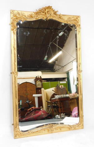 A George III style gilt wood and gesso ballroom mirror, with rococo C scroll frame enclosing a shaped and bevelled plate, 222cm high, 130cm wide.