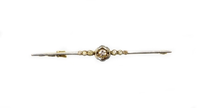 A diamond set floral bar brooch, the front in white metal with a tiny diamond in floral inclusion setting, flanked by six further tiny diamonds, on a yellow metal back and pin, unmarked, 5.5cm, 3.4g all in.