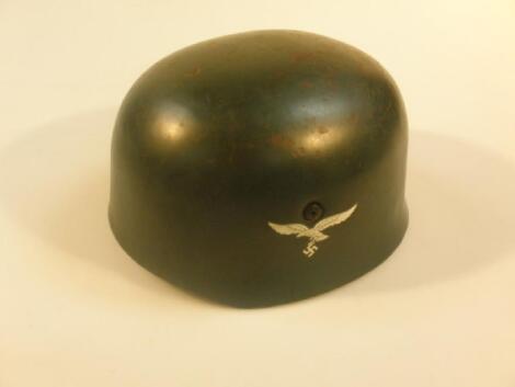 A German Third Reich paratroopers helmet with eagle swastika insignia